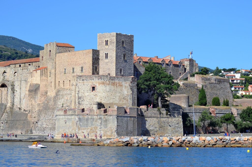 Le catamaran Navivoile naviguant dans la baie de Collioure avec une vue imprenable sur le Château Royal, ancienne résidence d'été des rois de Majorque, lors d'une Sortie en mer à Canet-en-Roussillon