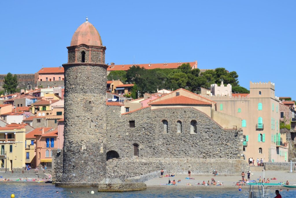 Le catamaran Navivoile entrant dans la baie de Collioure avec l'église Notre-Dame des Anges et son célèbre clocher au premier plan lors d'une Sortie en mer à Canet-en-Roussillon