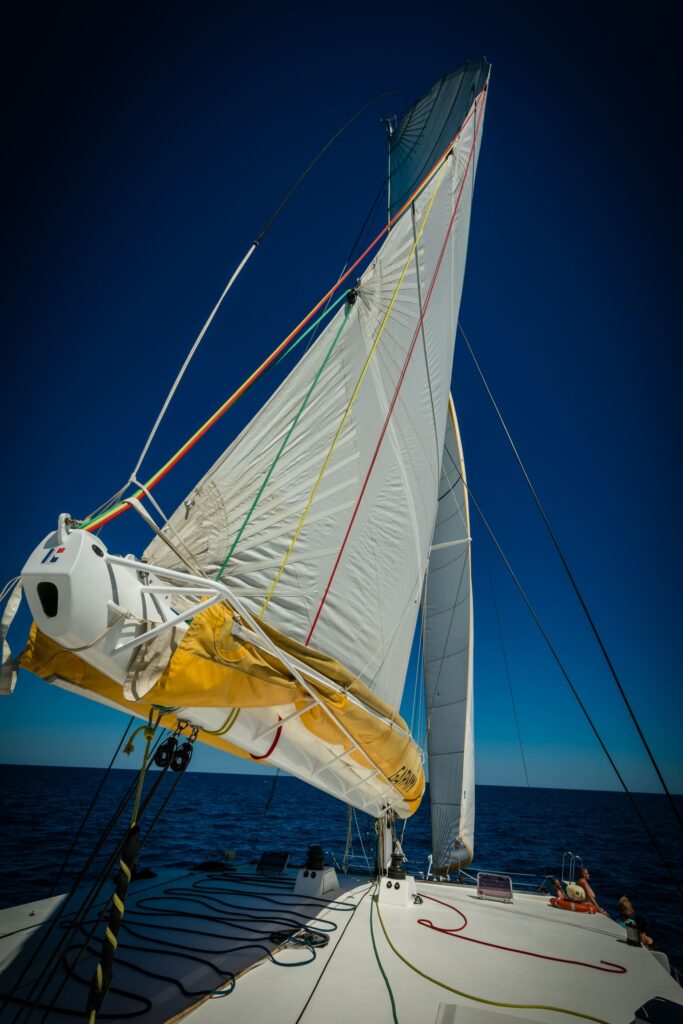 Le catamaran Navivoile naviguant toutes voiles déployées sous une légère brise de Sud-Est au large de Port-Vendres lors d'une Sortie en mer à Canet-en-Roussillon