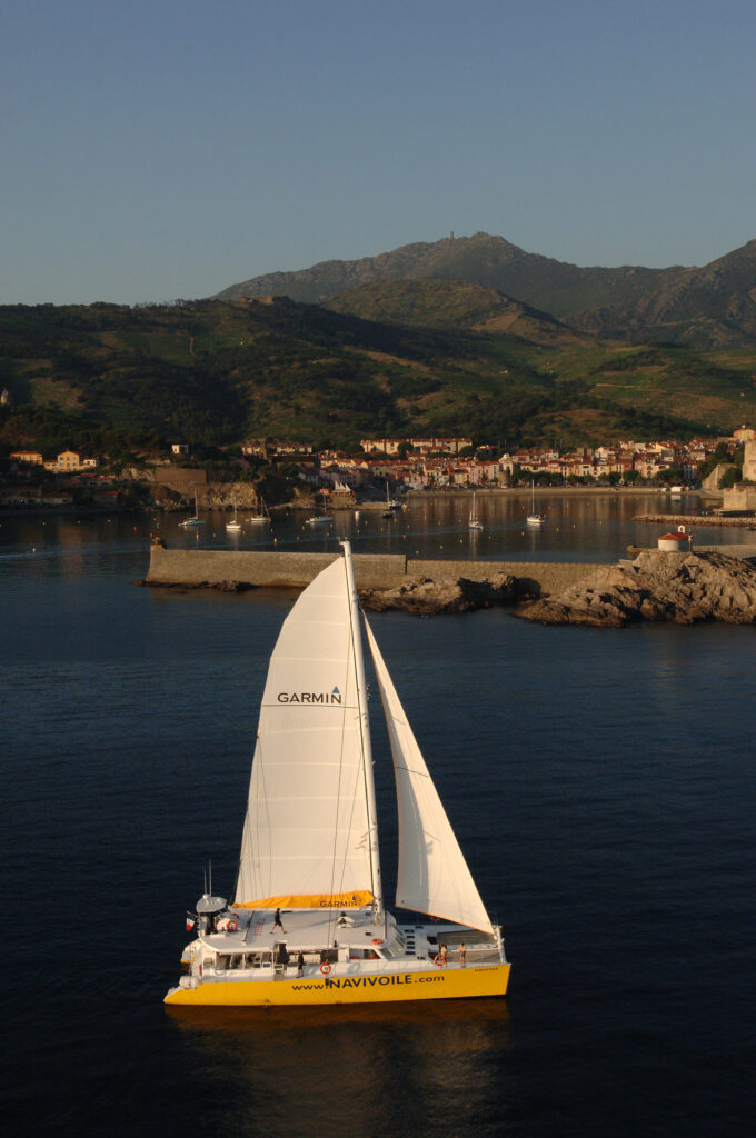 Le catamaran Navivoile toutes voiles dehors devant le Fort Miradou et la baie de Collioure en direction d'Argelès-sur-Mer