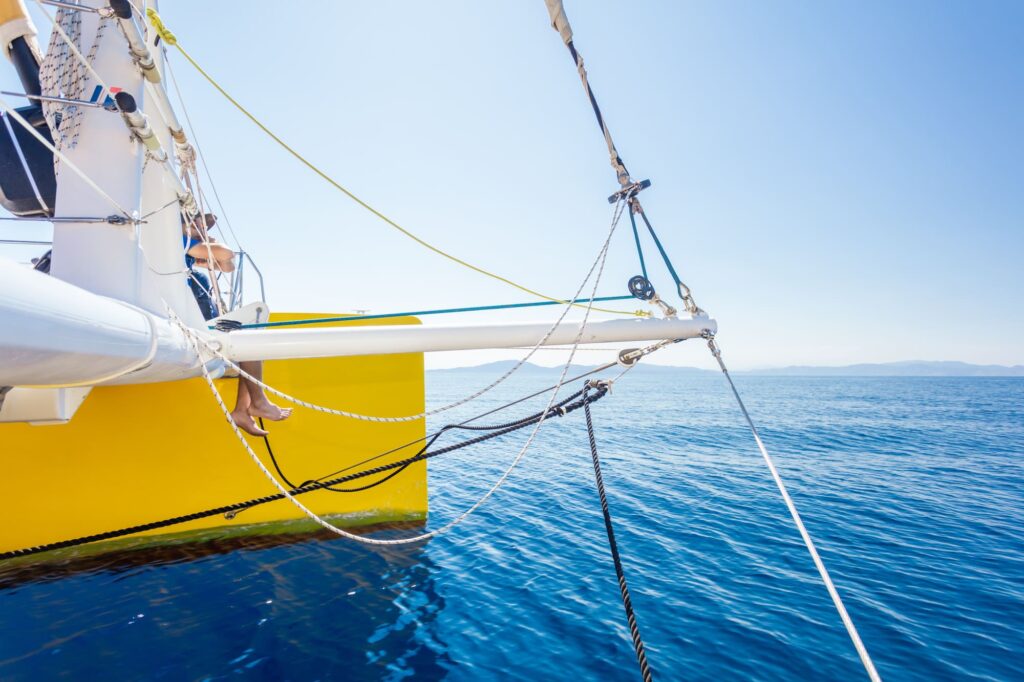 Photo d'une Promenade en mer à Port-Vendres. Le catamaran Navivoile navigue sous voiles par très légère brise au large de Cerbère, avec les côtes de l'Espagne se dessinant à l'horizon