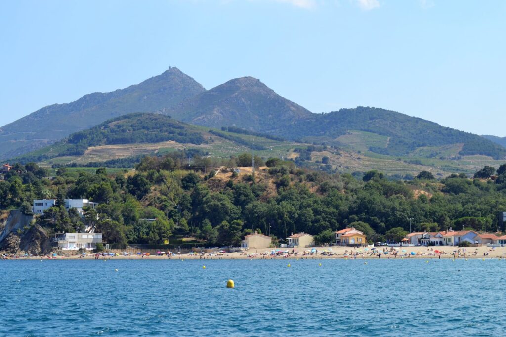 Vue depuis le Navivoile sur la Tour de la Madeloc dominant les montagnes et le racou au bord de l'eau