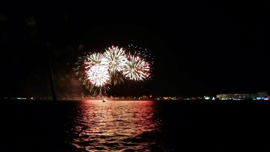 Vue depuis le large sur la jetée du port bondée et les fusées du Feu d’artifice Port Saint-Cyprien 15 août