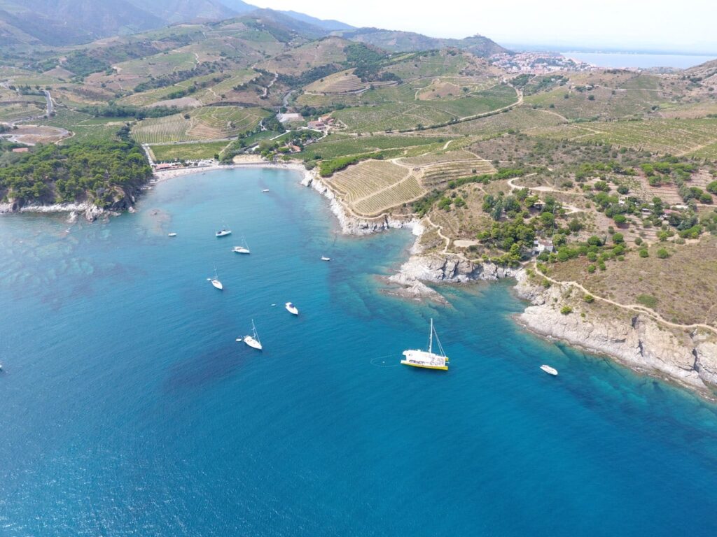 Vue aérienne par drone d'une activité pour groupe CSE : les salariés profitent d'une journée de cohésion à bord du NAVIVOILE dans la baie de Paulilles