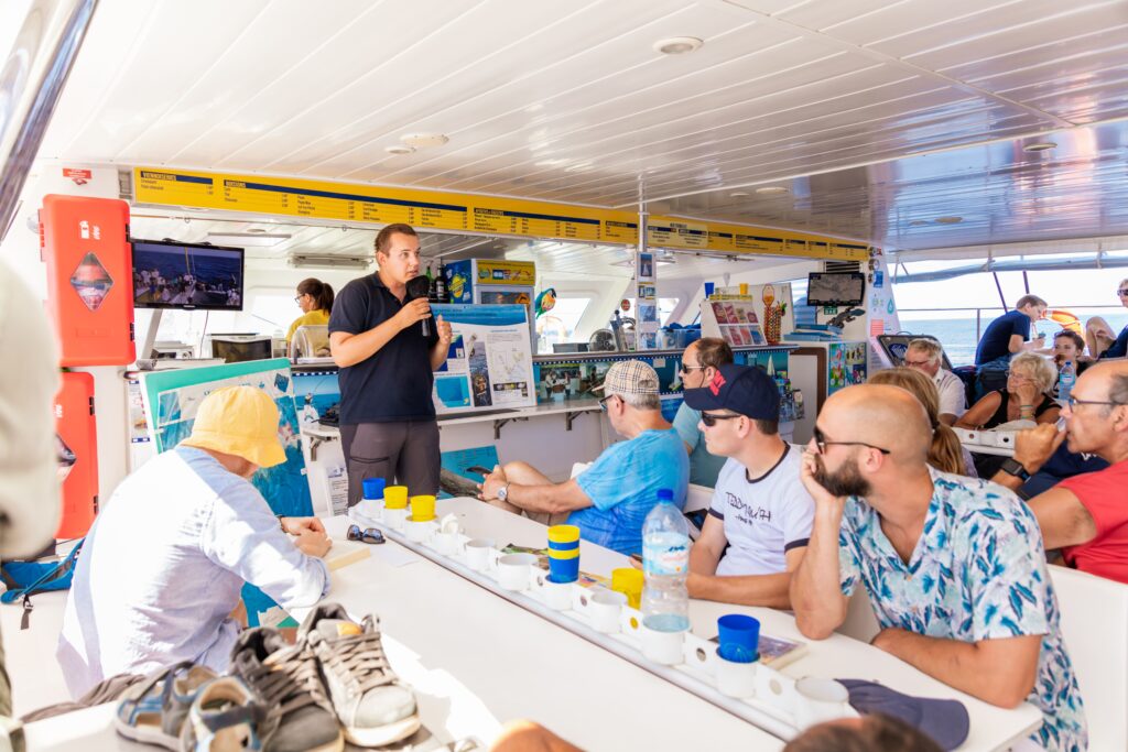 Un animateur du Parc Naturel Marin du Golfe du Lion donne une conférence sur les baleines et dauphins dans la nacelle du catamaran Navivoile. Cette sortie découverte au large de Canet sensibilise à la protection de la faune marine