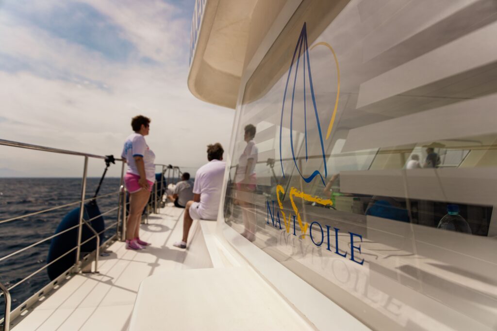 Un couple assis sur le pont bâbord du catamaran Navivoile profitant de la fraîcheur marine lors d'une sortie en mer en été au large d'Argelès-sur-Mer. Moment romantique sur le principal catamaran à voile à Canet-en-Roussillon et Port-Vendres