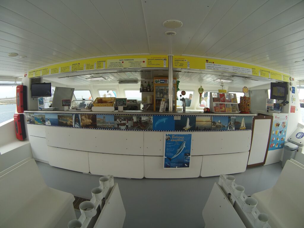 Vue panoramique en Fish Eye de l'intérieur de la nacelle et du bar du catamaran Navivoile à quai dans le port de Canet-en-Roussillon. Espace de réception spacieux du principal catamaran à voile à Canet-en-Roussillon et Port-Vendres