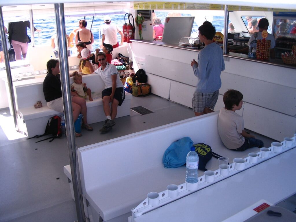 Passagers installés confortablement à l'ombre dans la nacelle panoramique au cours d'un voyage groupe organisé en catamaran NAVIVOILE, devant les plages d'Argelès-sur-Mer