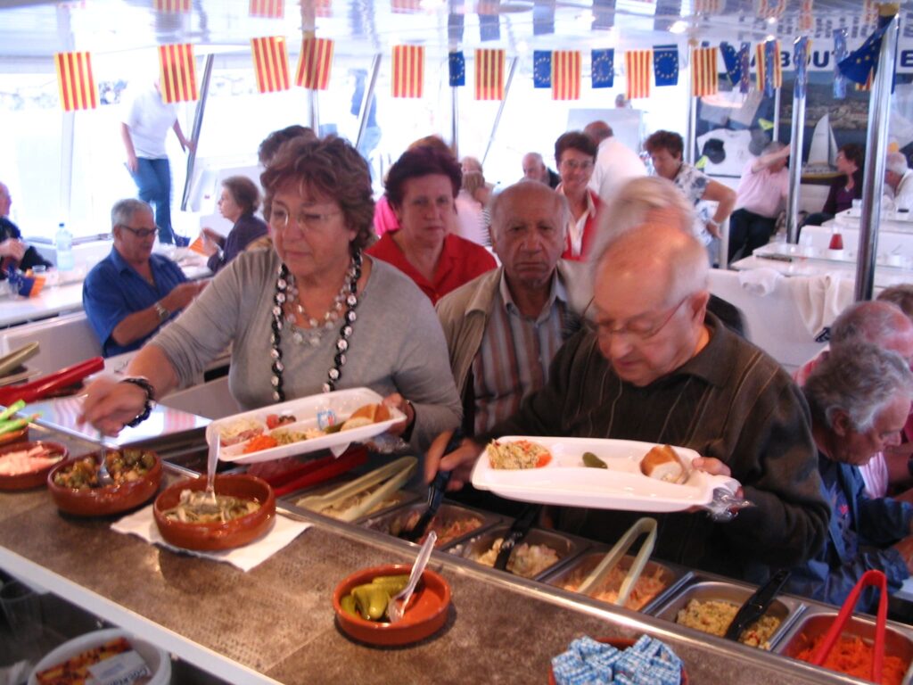 Moment de convivialité à bord du catamaran NAVIVOILE : déjeuner de grillades pour un groupe de voyageurs au mouillage dans la réserve naturelle de Paulilles