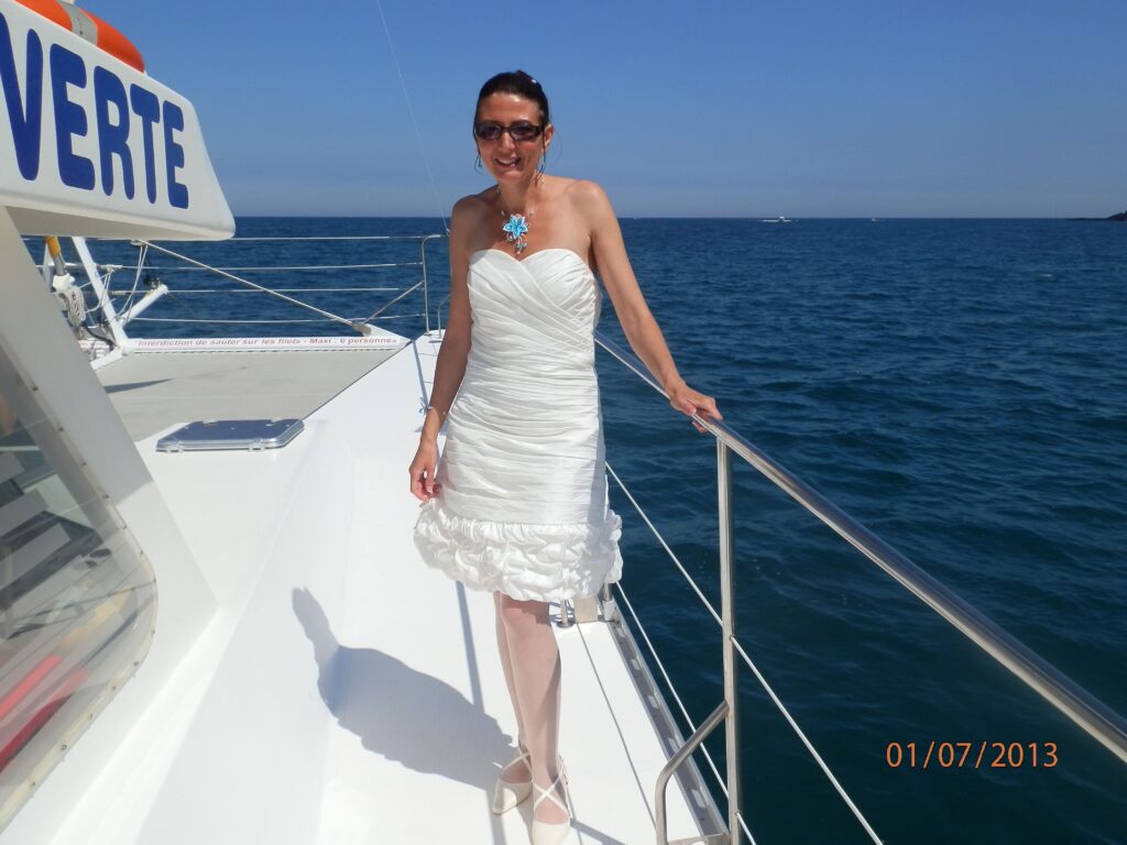 Portrait d'une mariée sur le pont avant du NAVIVOILE en navigation sous voiles devant la plage de Torreilles lors d'une activité pour groupe