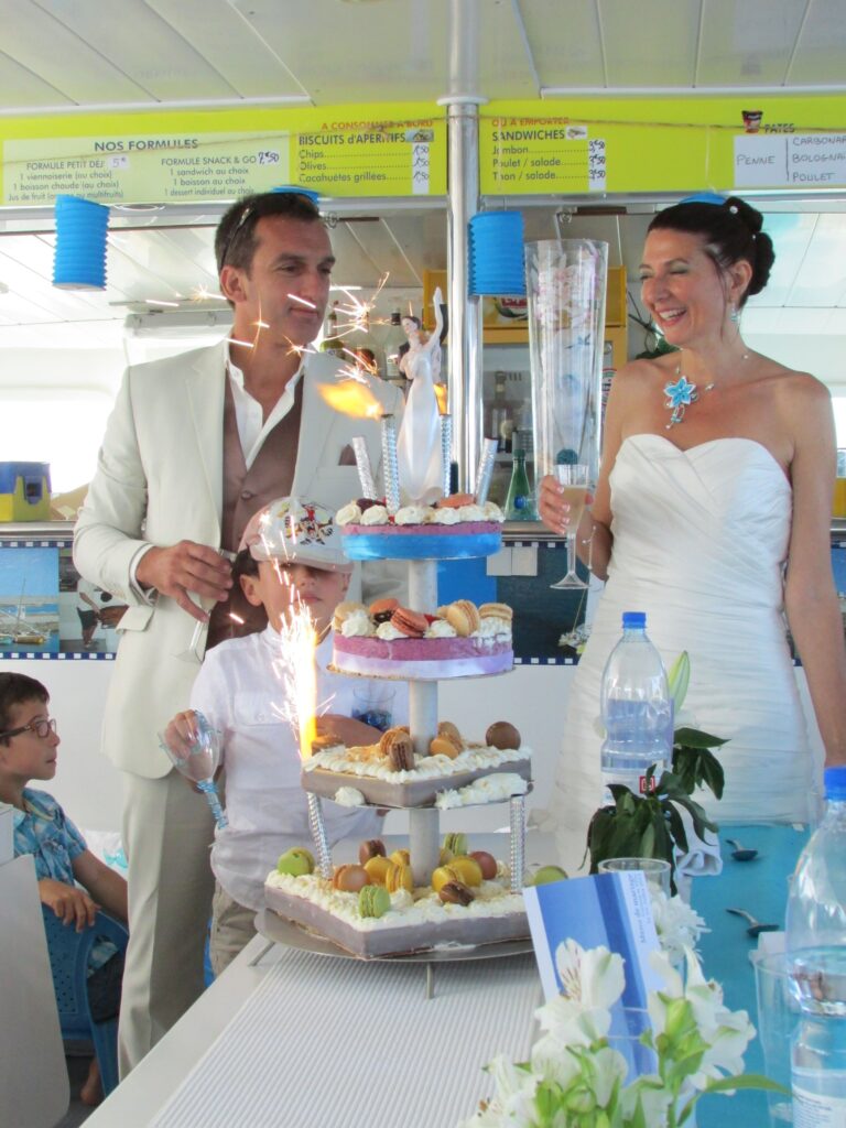 Couple de mariés célébrant leur union dans la nacelle panoramique du NAVIVOILE en navigation devant Port-Leucate lors d'une activité pour groupe