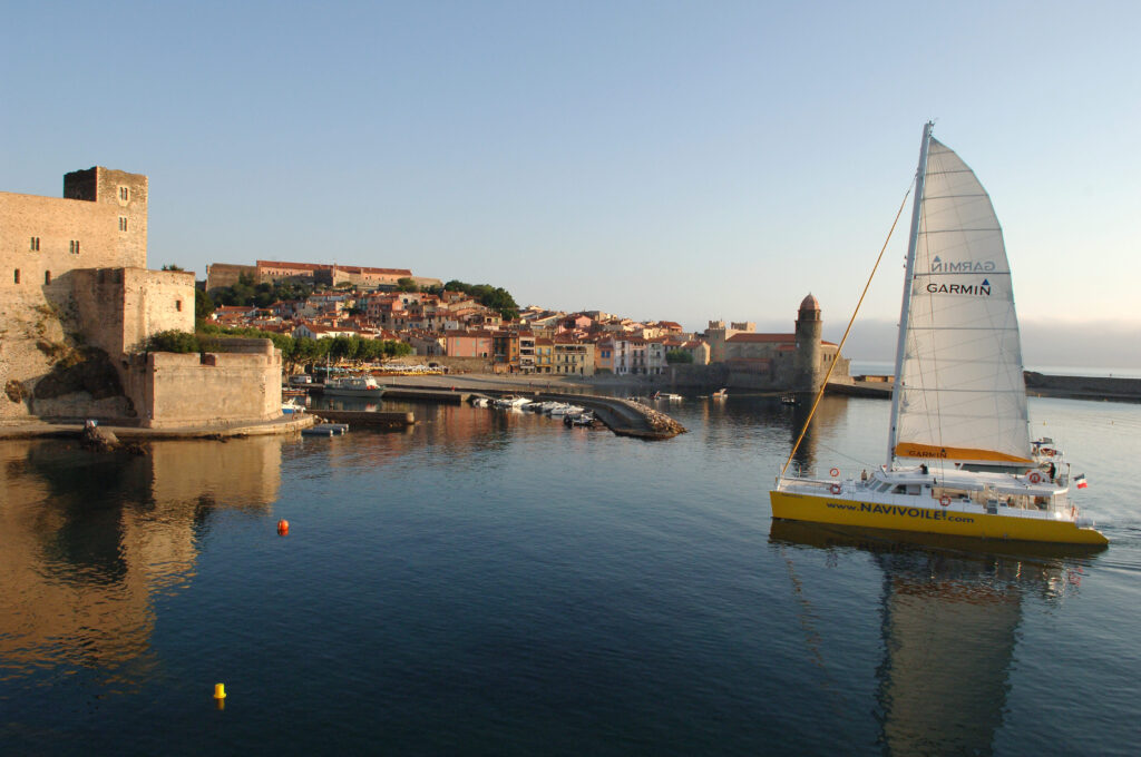 Le NAVIVOILE sous grand-voile entrant dans la baie de Collioure lors d'un voyage en groupe organisé en catamaran au mois de septembre